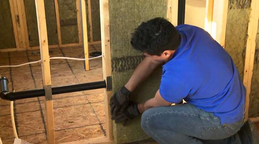 Installing soundproofing batts in interior partition walls of drywall