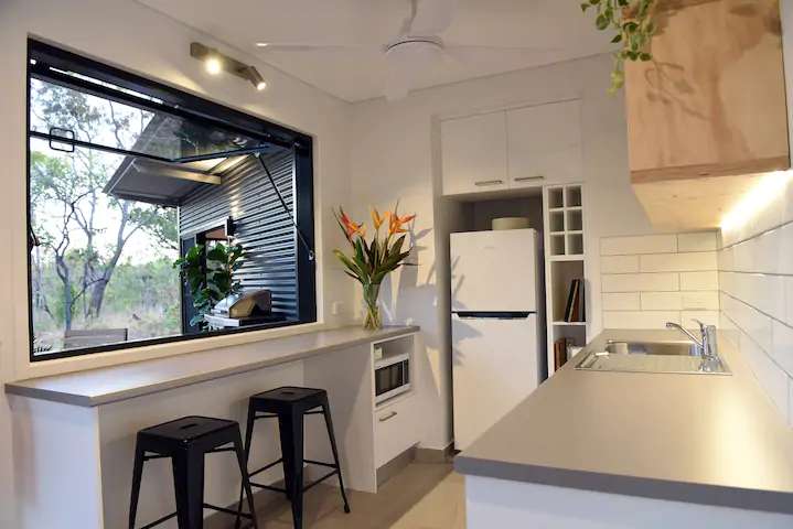 This shipping container house in a warm climate has wide opening windows for ventilation