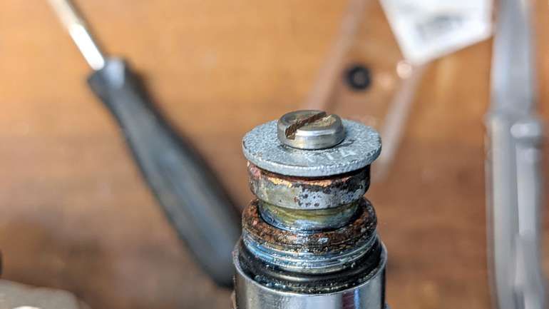 Use a heavy gauge steel washer to help force the new sealing washer into the cup on the faucet cartridge evenly