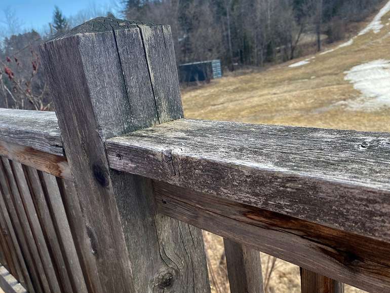 Staining a cedar deck to look like new - Before photo of the deck railing
