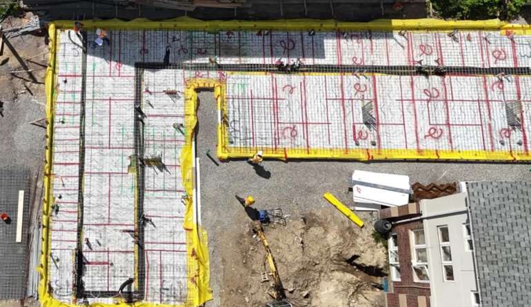 The prefab construction project uses a slab-on-grade foundation with no basement to minimize concrete use and embodied carbon consumption. Image @ Loftin Construction