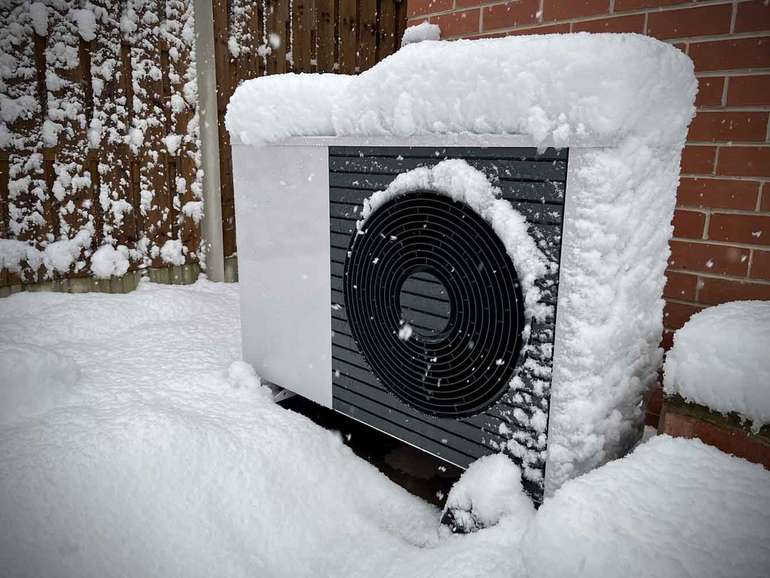 Heat pump covered in snow in a cold climate
