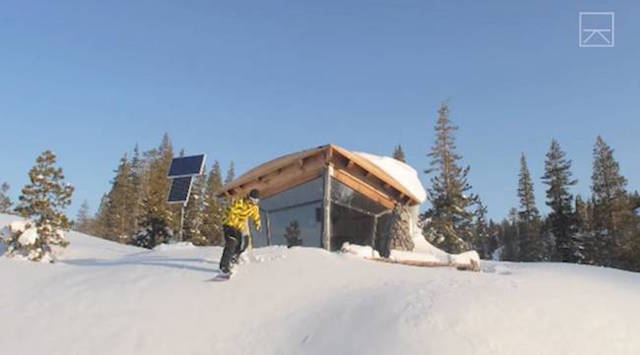 Mike Basich snowboarding outside his tiny but awesome off-grid cabin